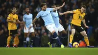 Bek Manchester City, Kyle Walker, berebut bola dengan pemain Wolverhampton Wanderers, Diogo Jota, pada laga Premier League di Stadion Etihad, Manchester, Senin (14/1). Manchester City menang 3-0 atas Wolverhampton Wanderers. (AP/Dave Thompson)