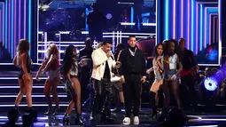 Luis Fonsi dan Daddy Yankee ditemani penari wanita seksi membawakan Despacito di panggung ajang Grammy Awards 2018 di New York, Minggu (28/1). Namun sayangnya, Justin Bieber tak hadir untuk melengkapi penampilan tersebut. (Matt Sayles/Invision/AP)