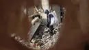 Perayaan Hari Anak Sedunia 2024 tidak bisa dirasakan oleh anak-anak yang berada di wilayah konflik. Tampak dalam foto, seorang anak laki-laki Palestina mengumpulkan barang-barang yang bisa diselamatkan dari puing-puing bangunan yang hancur akibat seragan Israel di Khan Yunis, Jalur Gaza selatan pada 19 November 2024. (Eyad BABA/AFP)