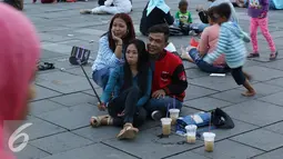 Sejumlah pengunjung berselfie di kawasan wisata Kota Tua, Jakarta, Senin (12/12). Kota Tua masih menjadi salah satu destinasi wisata bagi warga Jakarta dan sekitarnya untuk menghabiskan waktu liburan. (Liputan6.com/Immanuel Antonius)