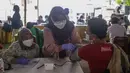 Petugas medis mengecek kesehatan warga sebelum mengikuti program vaksinasi massal Covid-19 di PMI Kota Bekasi, Jawa Barat, Sabtu (21/08/2021). Vaksin yang digunakan dalam vaksinasi massal tersebut yakni vaksin Astrazeneca. (Liputan6.com/Herman Zakharia)