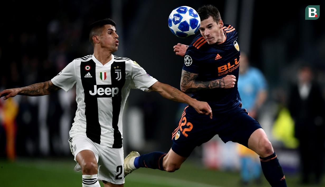 Bek Juventus, Joao Cancelo, berebut bola dengan striker Valencia, Santi Mina, pada laga Liga Champions di Stadion Allianz, Turin, Selasa (27/11). Juventus menang 1-0 atas Valencia. (AFP/Marco Bertorello)