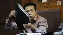Terdakwa dugaan korupsi proyek e-KTP Setya Novanto mengangkat berkas saat mengikuti sidang lanjutan di Pengadilan Tipikor, Jakarta, Senin (15/1). Sidang bergaendakan mendengar keterangan saksi. (Liputan6.com/Helmi Fithriansyah)