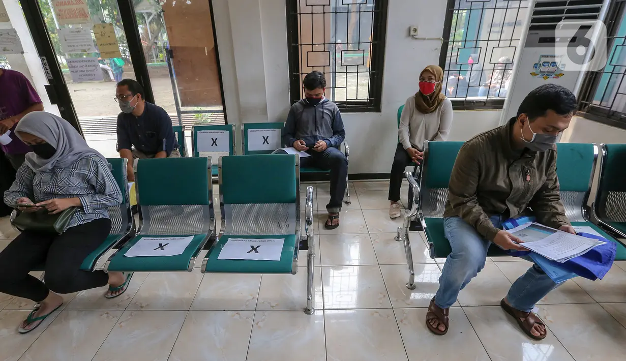 Warga duduk dengan aturan physical distancing saat antre pembuatan KTP Elektronik di Kecamatan Pamulang, Tangerang Selatan, Senin (15/6/2020). Dukcapil Tangsel membuka layanan rekaman E-KTP jelang Pilkada dengan menerapkan ketentuan New Normal. (Liputan6.com/Fery Pradolo)