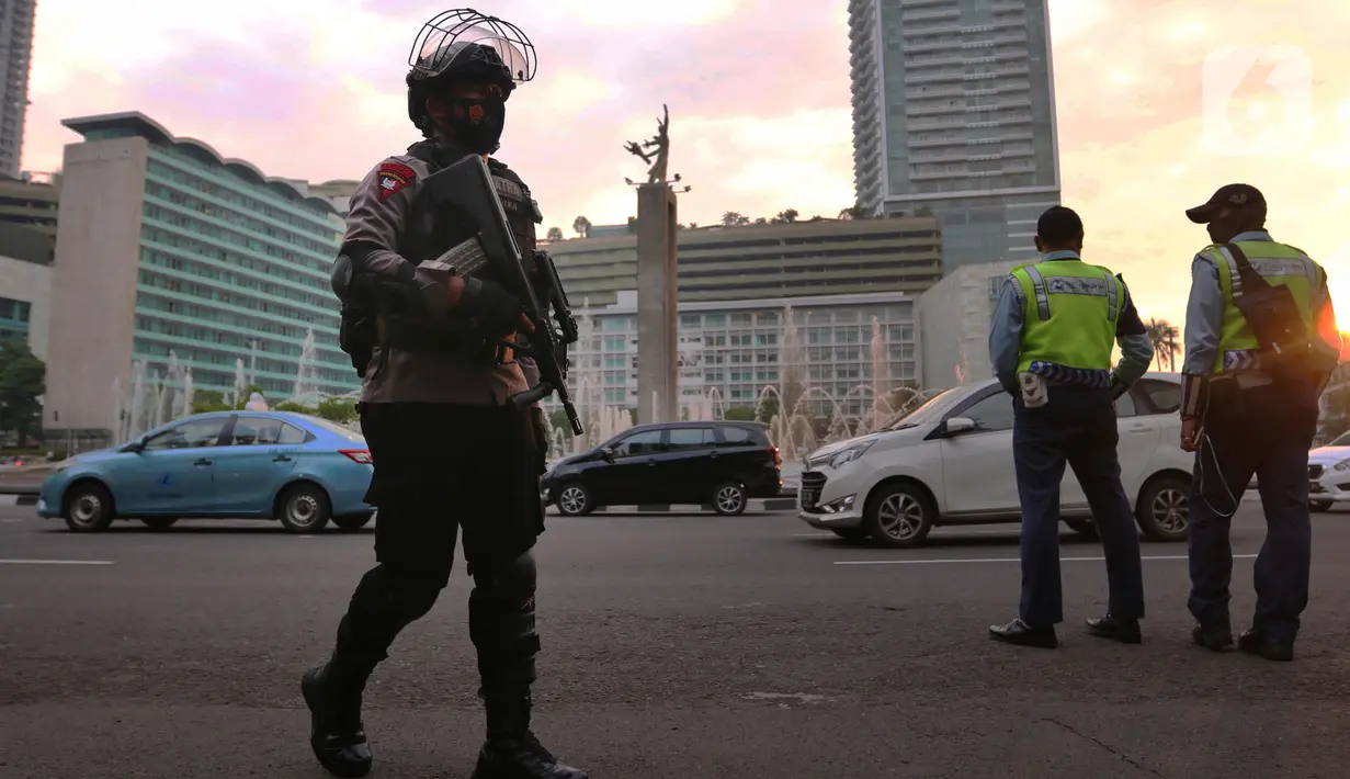 Aparat kepolisian bersenjata lengkap melakukan patroli di kawasan Bundaran Hotel Indonesia (HI),  Jakarta, Rabu (12/5/2021). Pengamanan ketat tersebut dilakukan untuk menjaga perayan Idul Fitri 1442 di jantung Ibu Kota. (Liputan6.com/Angga Yuniar)