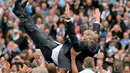 Pelatih Manchester City, Manuel Pellegrini, dilempar ke udara oleh pemainnya saat merayakan gelar juara Liga Primer di Stadion Etihad, Manchester (11/5/2014). (AFP PHOTO/Andrew Yates) 