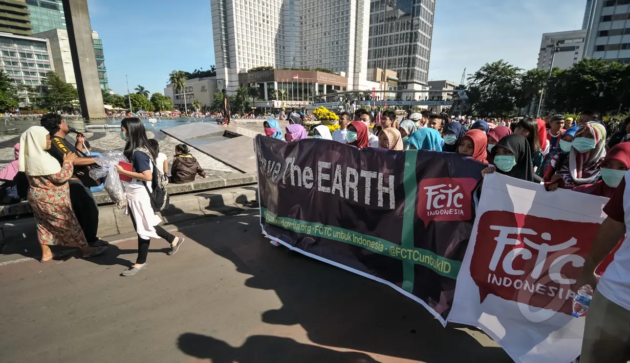 Sekelompok anak muda yang tergabung dalam Gerakan Muda FCTC saat melakukan Aksi Selamatkan Bumi dari Limbah Puntung Rokok di kawasan Bundaran HI, Jakarta, Minggu (26/4/2015). Kegiatan tersebut untuk memperingati Hari Bumi. (Liputan6.com/Faial Fanani)