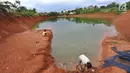 Anak-anak memancing pada bagian proyek pembangunan tol Cinere-Serpong yang berubah menjadi danau sedalam 4 meter di kawasan Cipayung, Tangsel, Banten (17/1). Pembangunan jalan Tol ini sepanjang 10,14 kilometer. (Merdeka.com/Arie Basuki)