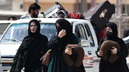 Kembalinya warga Pakistan di tengah meningkatnya eskalasi konflik antara Amerika Serikat dan Israel terhadap Iran yang kian memanas. Tampak dalam foto, warga Pakistan berjalan melintasi perbatasan Taftan, di provinsi Balochistan, Iran pada Selasa 3 Maret 2026, di tengah serangan Amerika Serikat dan Israel yang terus memanas. (Banaras KHAN/AFP)