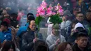 Warga memegang karangan bunga dan dupa ketika mereka berdoa di Kuil Lama di Beijing (5/2). Orang-orang China merayakan hari pertama Tahun Baru Imlek pada hari Selasa, Tahun Babi di zodiak Tiongkok dengan berdoa di kuil. (AP Photo/Mark Schiefelbein)