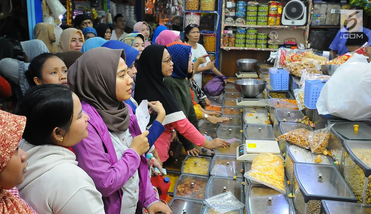 Pembeli mengantre saat membeli kue kering di Pasar Jatinegara, Jakarta, Senin (27/5/2019). Jelang Idul Fitri 2019, banyak warga berburu makanan ringan seperti kue kering untuk jamuan di hari raya. (Liputan6.com/Angga Yuniar)