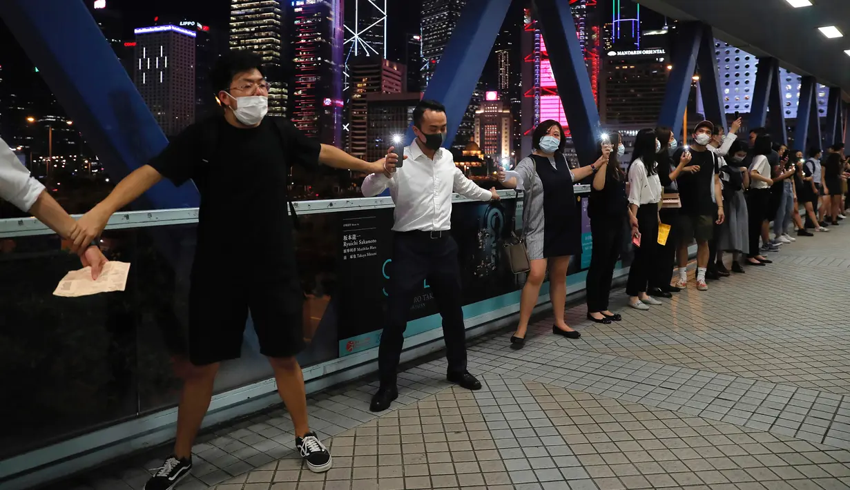Demonstran prodemokrasi membentuk rantai manusia di sepanjang jalan setapak Hong Kong, Jumat (23/8/2019). Aksi itu sekaligus memperingati kejadian 'Baltik Way' ketika sekitar 2 juta pengunjuk rasa membentuk rantai manusia yang melintasi Estonia, Latvia, dan Lithuania. (AP Photo/Kin Cheung)
