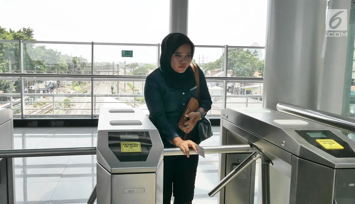 Penumpang tap tiket saat "Uji Coba Pelayanan Pengguna Jasa KRL" di Lantai Dua Stasiun Cakung, Jakarta, Selasa (9/10). BTPWJB Kemenhub telah merampungkan modernisasi Stasiun Cakung. (Liputan6.com/Herman Zakharia)
