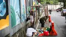 Seniman menyelesaikan pembuatan mural di kawasan Ragunan, Jakarta, Kamis (29/9/2022). Mural yang dibuat oleh seniman milenial dan Komunitas Ruang Seni Rupa tersebut bertemakan 'Jakarta untuk Indonesia'. (Liputan6.com/Faizal Fanani)