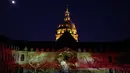 Sebuah instalasi cahaya menyinari tembok luar Hotel des Invalides di Paris selama pertunjukan "The Rise Of A New World", Prancis (25/6). (AFP/Ludovic Marin)