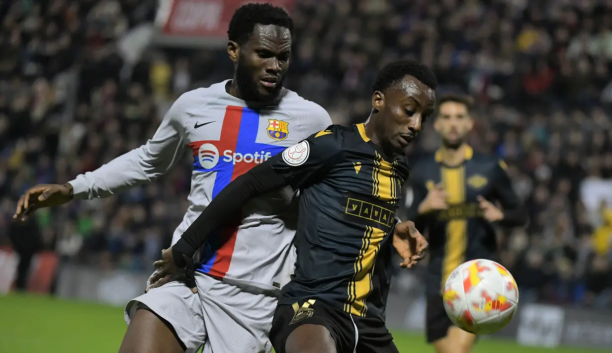 Gelandang Barcelona, Franck Kessie berusaha merebut bola dari pemain Intercity, Christian Koffi pada babak 32 besar Copa del Rey di stadion Ricardo Perez di Alicante, Spanyol, Kamis (5/1/2023). Barcelona menang atas Intercity dengan skor tipis 4-3. (AFP/Jose Jordan)