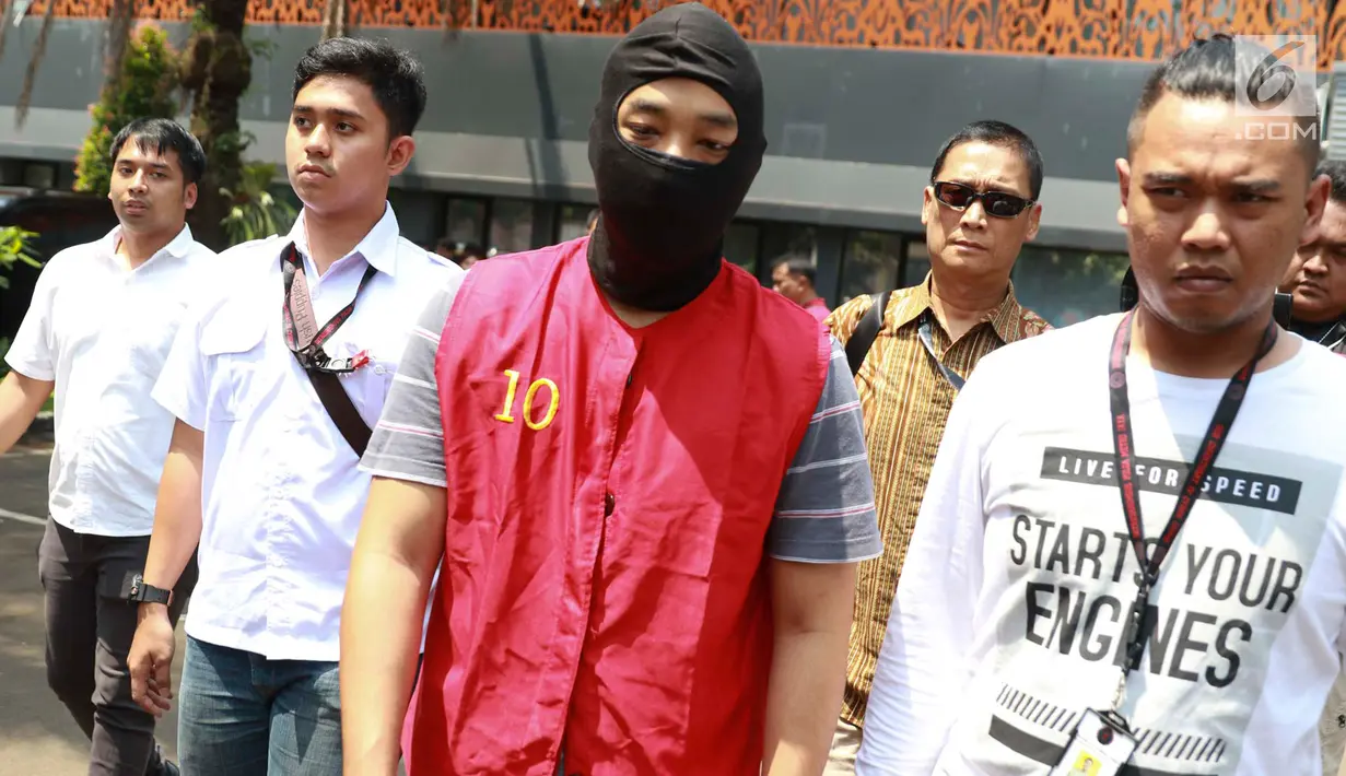 Tersangka Ramyadjie Priambodo dikawal polisi saat akan dilimpahkan ke kejaksaan di Polda Metro Jaya, Jakarta, Kamis (25/4). Pelimpahan tahap dua dilakukan usai kejaksaan menetapkan berkas perkara Ramyadjie lengkap (P-21) secara materiil dan formil pada 18 April 2019. (Liputan6.com/Immanuel Antonius)