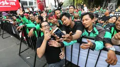 CEO GO-JEK Nadiem Makarim berswafoto bersama mitra GO-JEK saat menghadiri Pasar Malam di GO- FOOD Festival di GBK, Jakarta (11/5). Acara ini digelar sebagai bentuk apresiasi kepada mitra GO-JEK yang berprestasi. (Liputan6.com/Fery Pradolo)