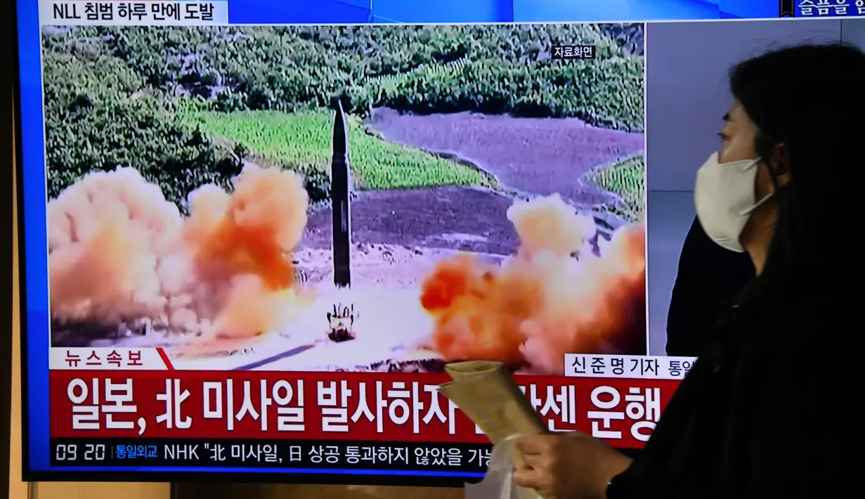 Seorang perempuan berjalan melewati layar televisi yang menunjukkan siaran berita dengan rekaman file uji coba rudal Korea Utara, di sebuah stasiun kereta api di Seoul, Kamis (3/11/2022). Militer Korea Selatan juga melaporkan peluncuran rudal tersebut, yang dilakukan di atas pantai timur Korea Utara. (Jung Yeon-je / AFP)