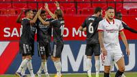 Para pemain Real Madrid merayakan gol yang dicetak ke gawang Sevilla pada laga Liga Spanyol di Stadion Ramon Sanchez Pizjuan, Minggu (6/12/2020). Real Madrid menang dengan skor 1-0. (AP/Angel Fernandez)