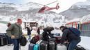 Sejumlah turis merapihkan koper bawaannya setelah dievakuasi dari ski Zermatt di  Taesch, Pegunungan Alpen Swiss (10/1). Bencana tersebut menyebabkan terputusnya jalur kereta api dan seluruh akses menuju Zermatt. (AFP Photo/Fabrice Coffrini)