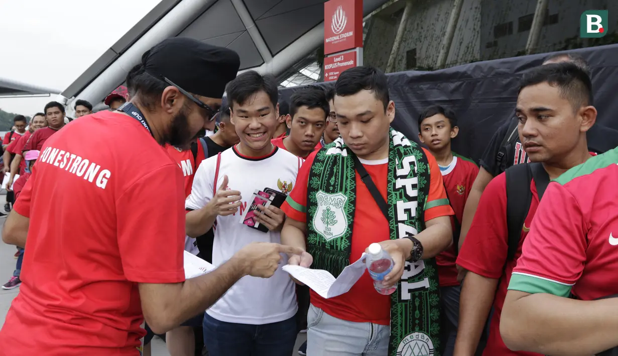 Petugas memeriksa tiket dari suporter Timnas Indonesia saat berada di Stadion Nasional, Singapura, Jumat (9/11). Indonesia akan melawan Singapura pada laga Piala AFF 2018. (Bola.com/M. Iqbal Ichsan)
