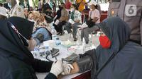 Petugas medis memeriksa kesehatan warga lanjut usia (lansia) sebelum disuntik vaksin Sinovac di Alun-Alun Bekasi, Jawa Barat, Rabu (23/2/2022). Sebanyak 600 dosis vaksin Sinovac disiapkan pemerintah setempat untuk warga lansia guna mencegah penyebaran COVID-19. (Liputan6.com/Herman Zakharia)