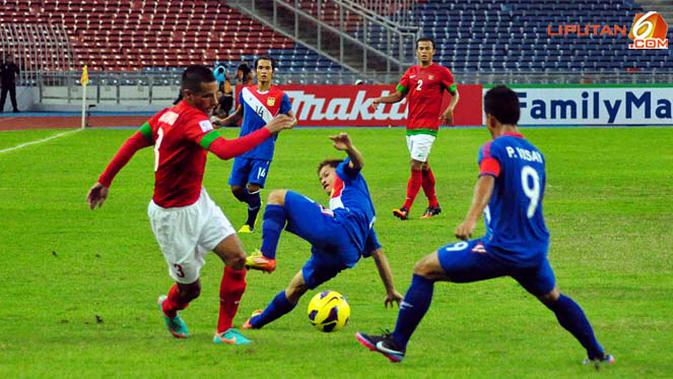 Pemain Timnas Indonesia Raphael Maitimo berusah keluar dari jagaan pemain Timnas Laos dalam Laga Piala AFF Suzuki 2012 Minggu 25 November 2012, di Stadion Bukit Jalil, Kuala Lumpur Malaysia. Pertandingan berakhir dengan Skor 2-2.