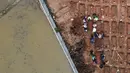 Foto udara memperlihatkan kendaraan alat berat menyelesaikan penggarapan lahan untuk lokasi pemakaman khusus Covid-19 di Rorotan, Jakarta Utara, Kamis (3/6/2021). Sejak dibuka pada akhir Maret lalu, TPU ini diutamakan melayani pemakaman bagi jenazah Covid-19 ber-KTP DKI. (merdeka.com/Imam Buhori)