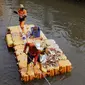 Petugas UPK Badan Air Pemprov DKI Jakarta membersihkan ceceran sampah di sepanjang Anak Sungai Ciliwung yang membelah kawasan Jalan Gajah Mada dan Hayam Wuruk, Selasa (9/7/2019). Pembersihan ini untuk menghindari penumpukan sampah dan memperlancar aliran air. (Liputan6.com/Helmi Fithriansyah)