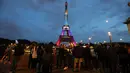 Pengunjung mengambil gambar Menara Eiffel yang diterangi dengan huruf '300 juta terima kasih' di Paris, Kamis (28/9). Menara Eiffel adalah salah satu monumen terpopuler di dunia, menarik lebih dari 5,8 juta pengunjung tahun lalu. (LUDOVIC MARIN/AFP)