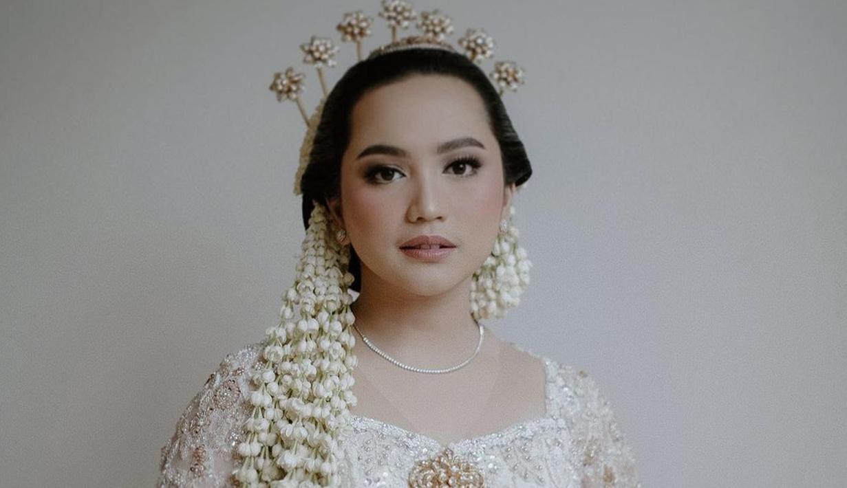 Paras cantik Rachel dirias flawless oleh MUA Jasmine Elishava. Dalam makeup tersebut menonjolkan bagian mata Rachel Amanda yang cantik. Kemudian bibirnya dipulas dengan pipi dan lipstik berwarna koral yang memberikan kesan elegan. (Liputan6.com/IG/@hibikiwedding)