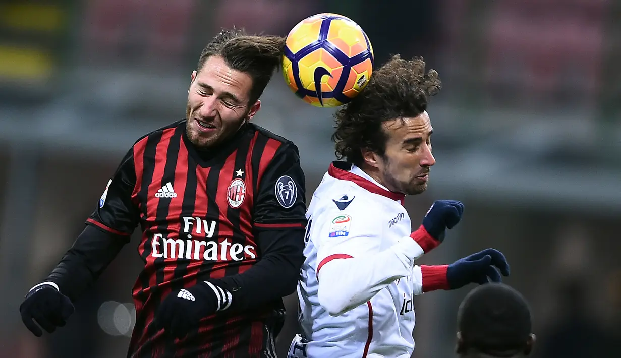 Gelandang AC Milan, Andrea Bertolacci (kiri) berebut bola udara dengan gelandang Cagliari, Davide Di Gennaro pada lanjutan Liga Italia di Stadion San Siro (9/1). AC Milan menang tipis atas Cagliari dengan skor 1-0. (AFP Photo/Filippo Monteforte)
