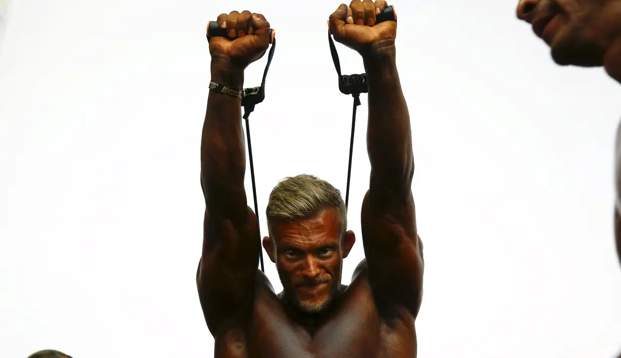 Peserta binaraga melakukan pemanasan di belakang panggung saat menunggu dimulainya kontes Arnold Klasik Eropa 2015 di Madrid, Spanyol, Jumat (25/9). (REUTERS/Susana Vera)