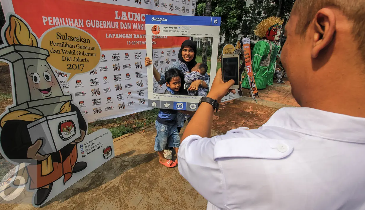 Warga berfoto menggunakan atribut saat launching pemilihan Gubernur dan Wakil Gubernur 2017 di Jakarta, Minggu (18/9). Launching tersebut bertujuan untuk mengedukasi masyarakat Jakarta menjelang Pilkada 2017. (Liputan6.com/Faizal Fanani)