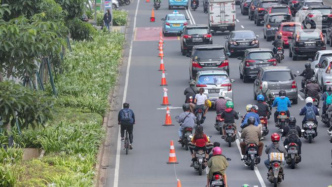 Warga bersepeda setelah jam kerja di jalur khusus sepeda kawasan Jalan Sudirman, Jakarta, Selasa (14/7/2020). Jam operasional dari Senin sampai Jumat pagi harinya jam 06.00 – 08.00 WIB, kemudian untuk sore dari jam 16.00 – 18.00 WIB. (Liputan6.com/Fery Pradolo)