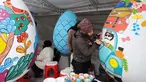 Para pelukis menghias telur-telur besar menjelang perayaan tahun baru Nowruz di Taman Mellat, Teheran, pada 27 Februari 2024. (ATTA KENARE/AFP)