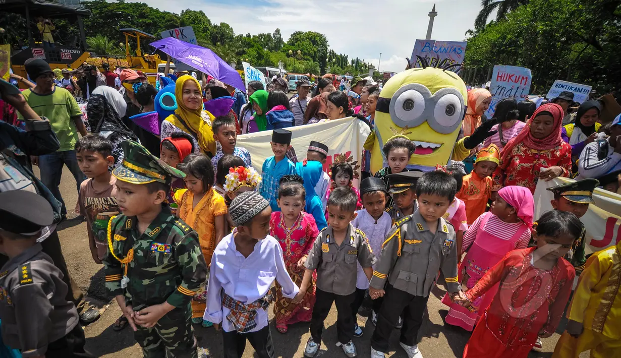 Sejumlah anak kecil yang mengenakan pakaian adat tradisional dan seragam TNI Polri ikut meramaikan aksi Karnaval Rakyat Lawan Korupsi dari patung kuda menuju Istana Negara, Jakarta, Rabu (8/4/2015). (Liputan6.com/Faizal Fanani)