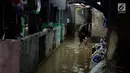Warga melintasi banjir di permukiman Jati Padang, Jakarta, Kamis (30/11). Banjir yang terjadi tersebut akibat tanggul darurat di Kali Pulo jebol karena genangan air yang cukup deras dan membanjiri permukiman sekitar. (Liputan6.com/Johan Tallo)