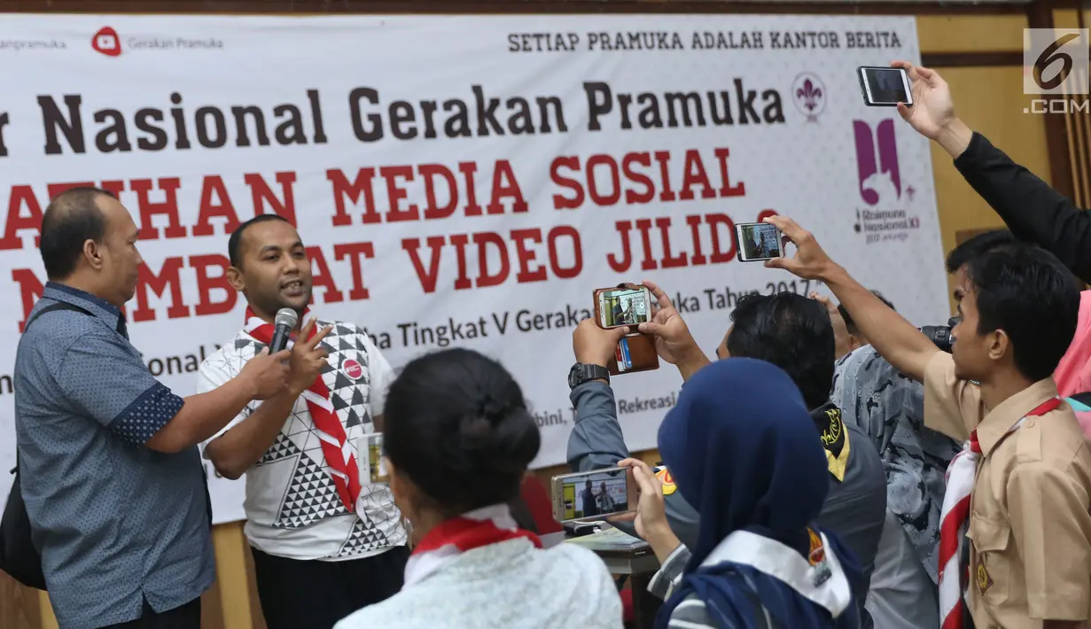 Anggota Pramuka mempraktikkan cara mengambil gambar dengan ponsel di sela-sela materi Pelatihan Media Sosial dan Membuat Video Jilid 2, Jakarta, Sabtu (5/8). Pelatihan dalam rangka Raimuna Nasional XI Pramuka. (Liputan6.com/Helmi Fithriansyah)