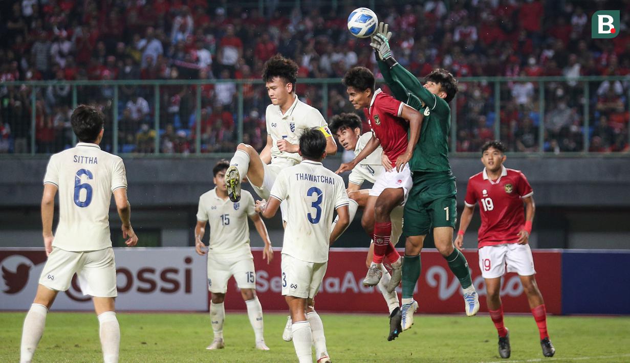 <p>Pemain Timnas Indonesia U-19,&nbsp;Ahmad Rusadi berebut bola diudara dengan penjaga gawang Thailand yang dijaga Narongsak Naengwongsa dalam pertandingan babak penyisihan Grup A Piala AFF U-19 yang berlangsung di Stadion Patriot Candrabhaga, Bekasi, Rabu (6/7/2022). (Bola.com/Bagaskara Lazuardi)</p>