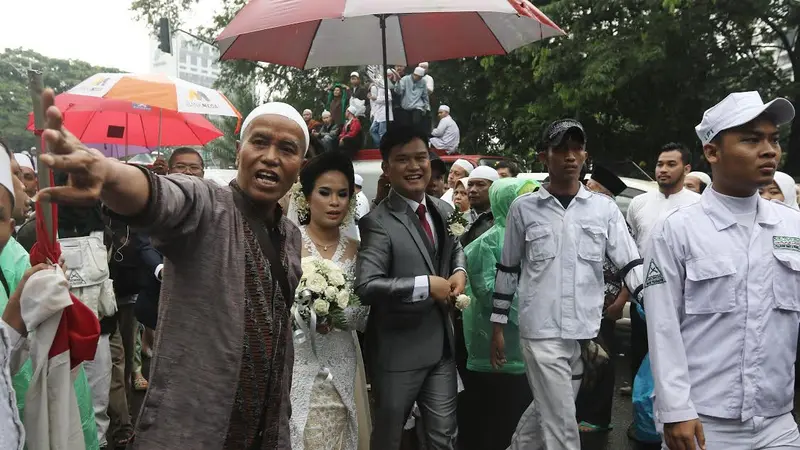 Pasangan pengantin yang akan menikah di Katedral dipayungi massa aksi 112