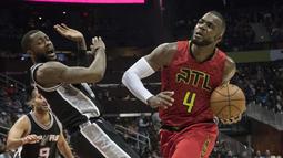 Pemain Atlanta Hawks, Paul Millsap (kanan) menggiring bola melewati hadangan pemain Spurs, Jonathon Simmons pada lanjutan NBA basketball game di Philips Arena, (01/01/2017). Atlanta menang 114-112. (AP/John Amis)