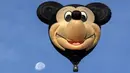 Balon udara berbentuk kepala Mickey Mouse terbang selama  Festival Balon Udara Internasional XVIII di  Leon, negara bagian Guanajuato, Meksiko pada 16 November 2019. Tak hanya balon udara biasa, banyak yang memiliki bentuk, serta warna unik menyemarakkan langit Kota Leon. (MARIO ARMAS / AFP)