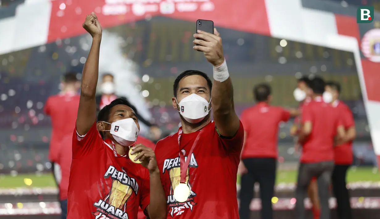 Kiper merangkap kapten Persija Jakarta, Andritany Ardhiyasa (kanan) bersama Ramdani Lestaluhu melakukan selebrasi usai menjuarai Piala Menpora 2021 di Stadion Manahan, Solo, Minggu (25/4/2021). (Bola.com/M Iqbal Ichsan)