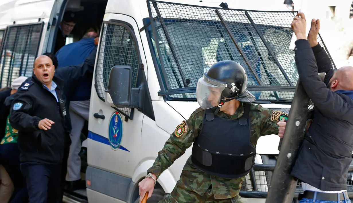 Polisi Palestina mencegah demonstran mendekati mobil yang membawa delegasi para politikus AS yang tengah mengunjungi Ramallah di Tepi Barat, Kamis (22/2). Kunjungan ini bertujuan untuk mendatangi sebuah perusahaan polling Palestina. (ABBAS MOMANI/AFP)