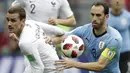 Striker Prancis, Antoine Griezmann, berebut bola dengan bek Uruguay, Diego Godin, pada laga perempat final Piala Dunia di Stadion Nizhny Novgorod, Nizhny Novgorod, Jumat (6/7/2018). Prancis menang 2-0 atas Uruguay. (AP/Natacha Pisarenko)