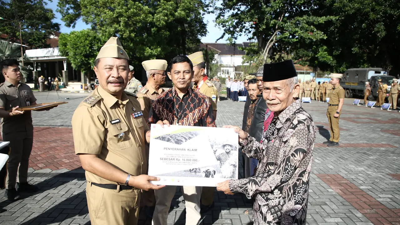 Penjabat Bupati Garut, Barnas Adjidin, secara simbolis menyerahkan klaim asuransi usaha tani padi (AUTP) perwakilan empat kelompok tani, terdampak gagal panen di Garut saat ini. (Liputan6.com/Jayadi Supriadin)