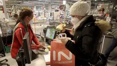 Seorang perempuan mengenakan masker FFP2 jenis respirator saat berbelanja di supermarket di Wina, Austria, Senin (25/1/2021). Mulai 25 Januari 2021, warga Austria diwajibkan mengenakan masker FFP2 di supermarket, apotek, pompa bensin, dan di transportasi umum. (AP Photo/Ronald Zak)