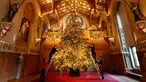Dekorator menghias pohon cemara besar dari Windsor Great Park di ujung aula St. George di Windsor Castle, Inggris, 30 November 2018. Pohon setinggi 6 meter itu dihias dengan pernak-pernik Natal berwarna emas serta ornamen kerajaan.  (AP/Frank Augstein)